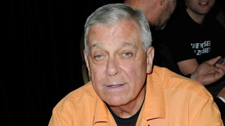 David Emge portant une chemise orange souriant lors d'un événement