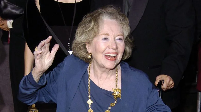 Glynis Johns souriante avec une main levée lors d'un événement