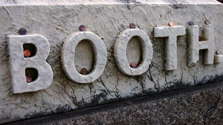 Monnaies couvrant la pierre tombale de la famille Booth