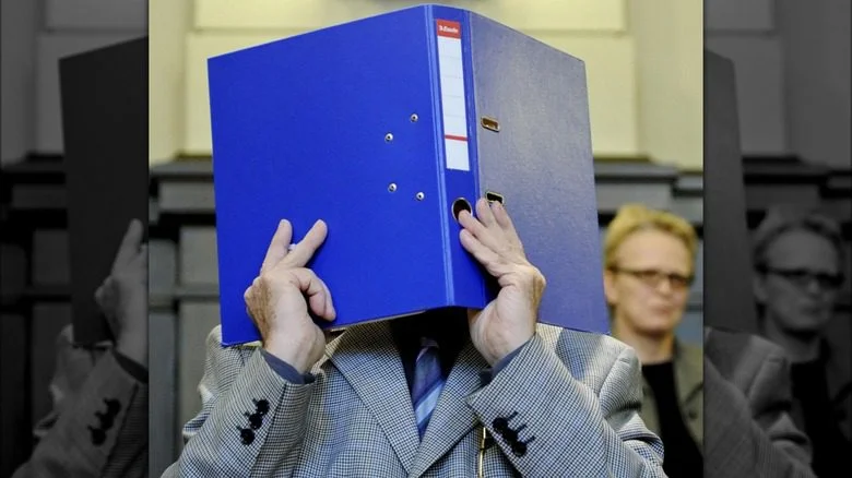 Josef Fritzl cachant son visage dans un livre