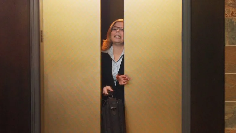 Femme quittant l'ascenseur avec la porte fermée