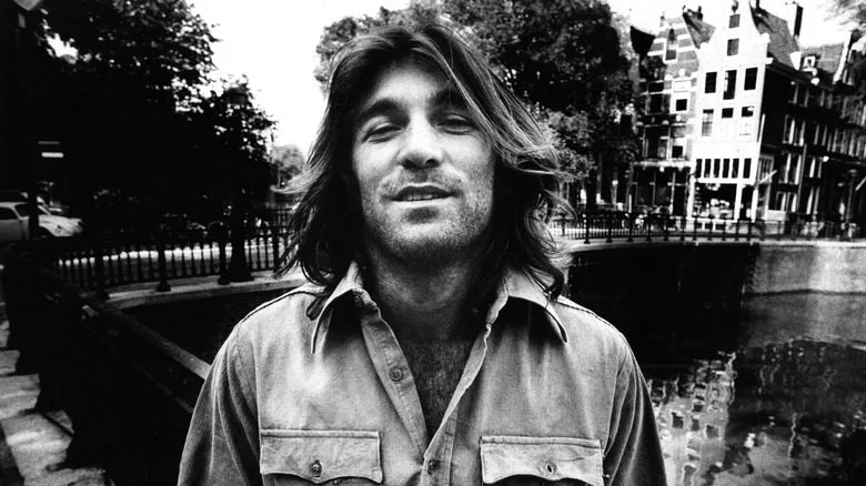 Dennis Wilson posant devant un pont