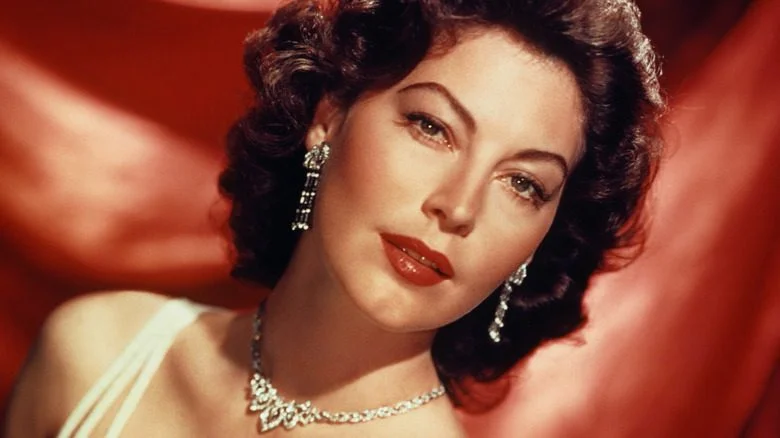 Ava Gardner en robe devant un rideau rouge