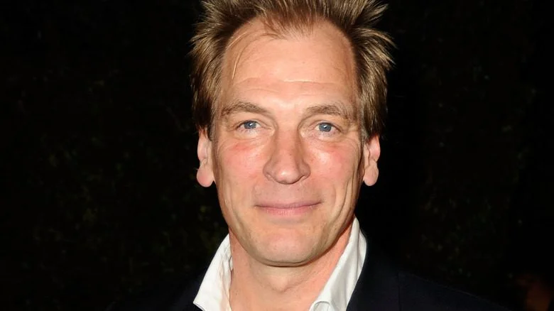 Julian Sands souriant fond noir