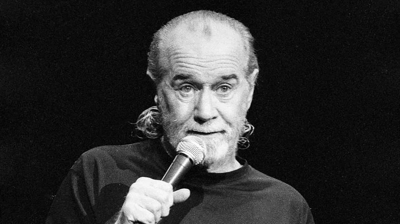 George Carlin sur scène avec un micro.