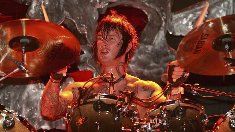 Jimmy Sullivan jouant de la batterie torse nu