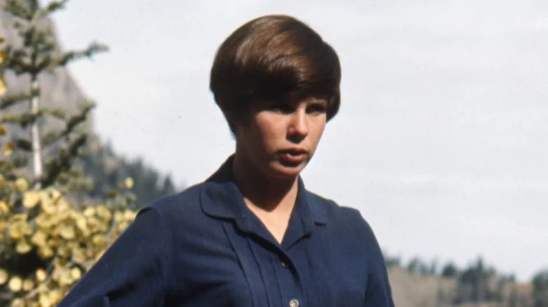 Kim Darby les cheveux courts plissant les yeux en robe bleue