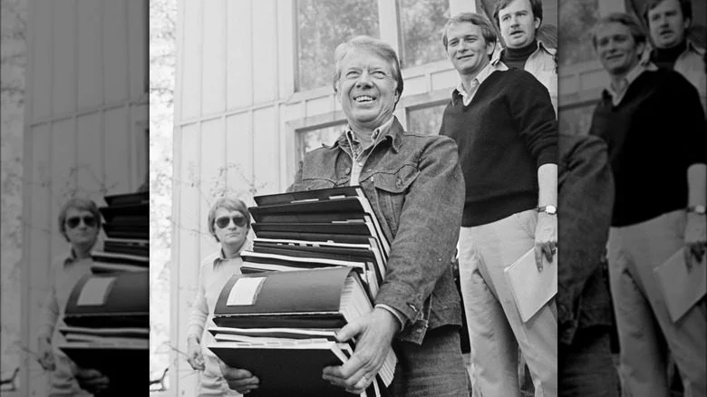 Jimmy Carter souriant transportant des dossiers