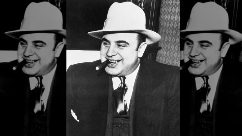 AL Capone souriant avec un chapeau et un cigare dans la bouche
