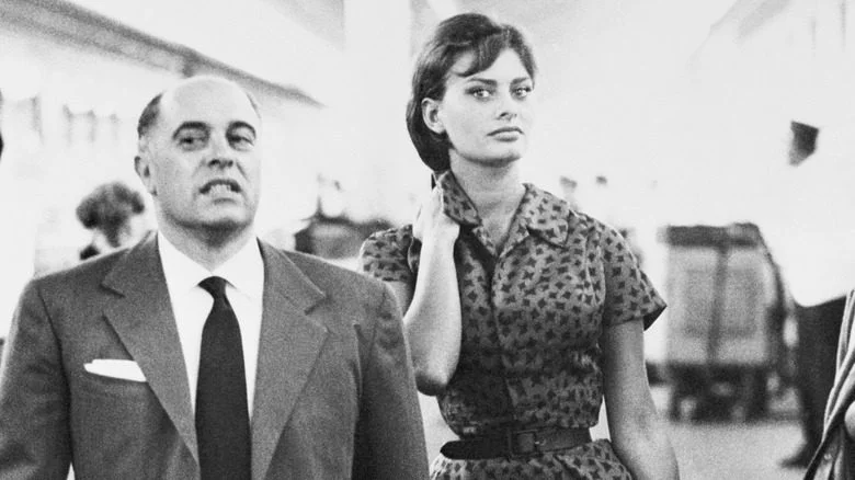 Carlo Ponti et Sophia Loren marchant à travers un aéroport