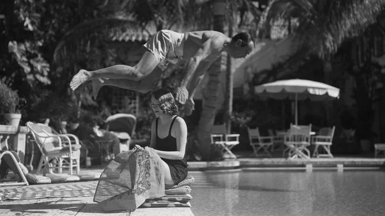 Douglas Fairbanks Sr. plongeant par-dessus Sylvia Ashley dans la piscine