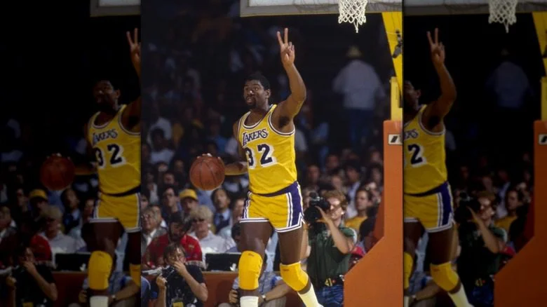 Magic Johnson fait le signe de la paix