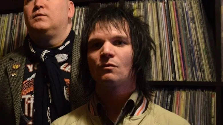 Jon Paul Steuer aux cheveux hérissés avec des disques en arrière-plan