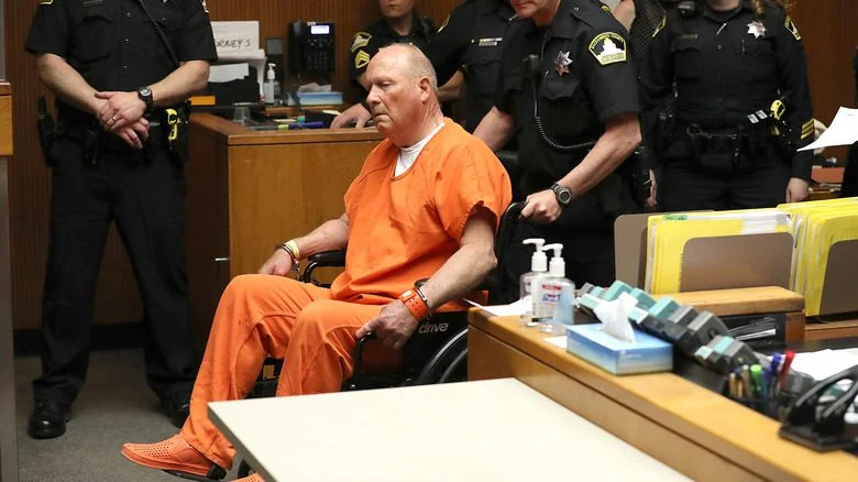 Joseph James DeAngelo en combinaison orange, en fauteuil roulant, au tribunal