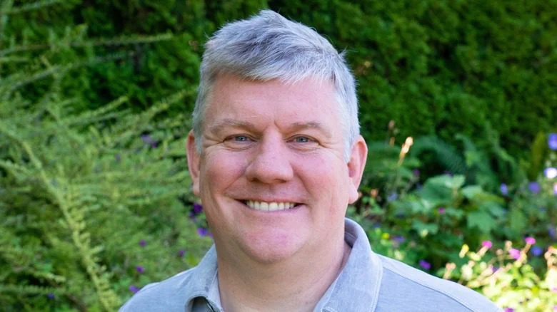 Mike Hanlon souriant dans un jardin