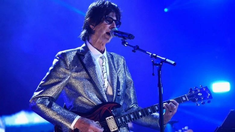 Ric Ocasek jouant de la guitare sur scène