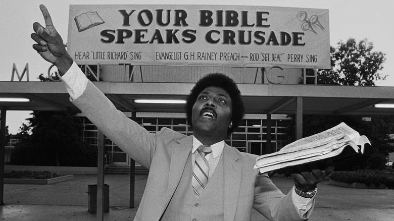 Little Richard levant une Bible en prêchant