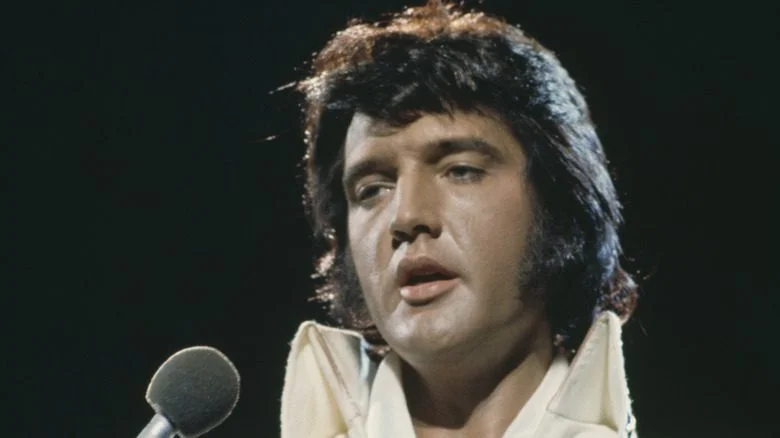 Elvis en costume blanc avec un micro