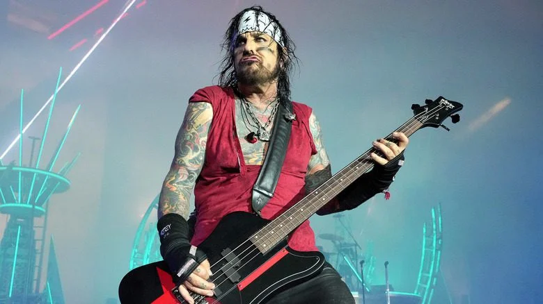 Nikki Sixx avec un bandana jouant de la basse sur scène
