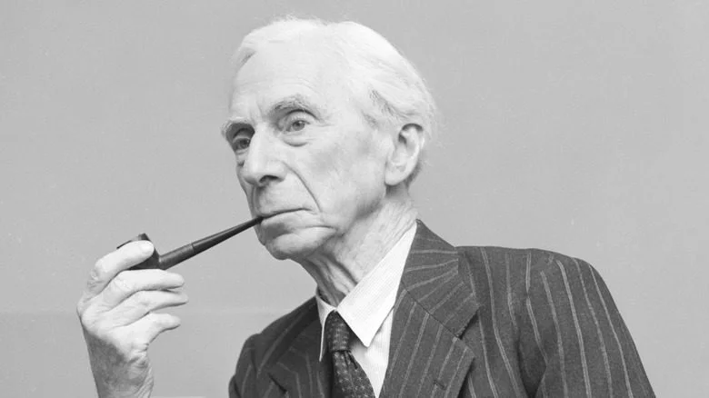 Bertrand Russell en costume rayé tenant une pipe