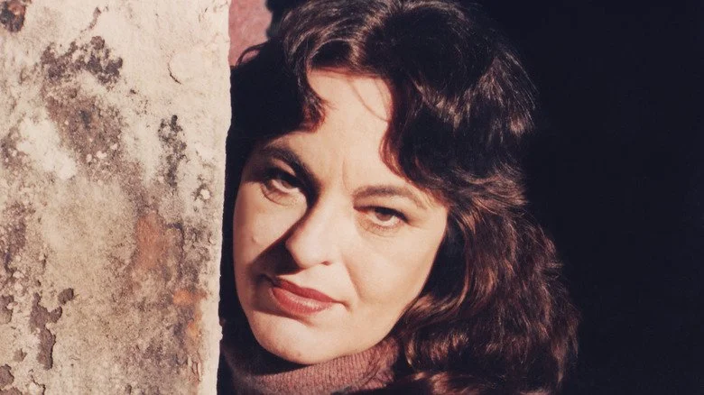 Sondra London posant contre le côté d'un bâtiment