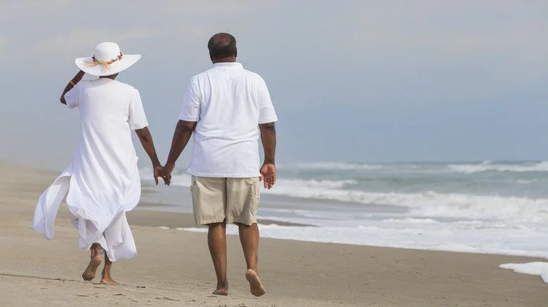 Couple âgé marchant sur la plage