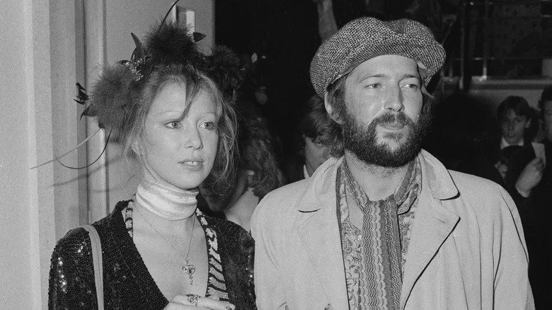 Pattie Boyd regardant Eric Clapton en chapeau, plissant les yeux