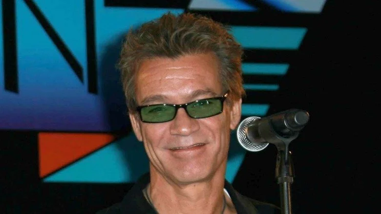 Eddie Van Halen souriant avec des lunettes de soleil lors d'un événement