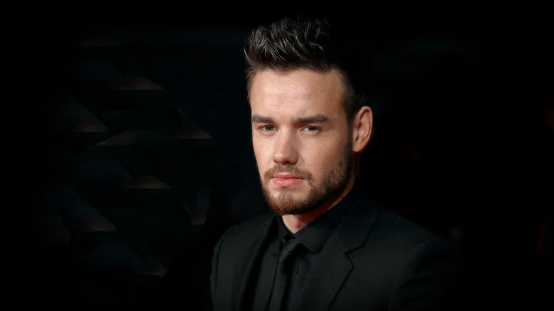 Liam Payne posant devant un fond sombre