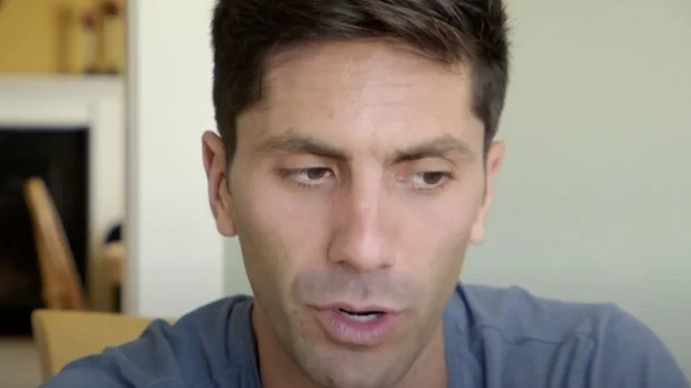 Nev Schulman regardant distraitement à son bureau dans Catfish