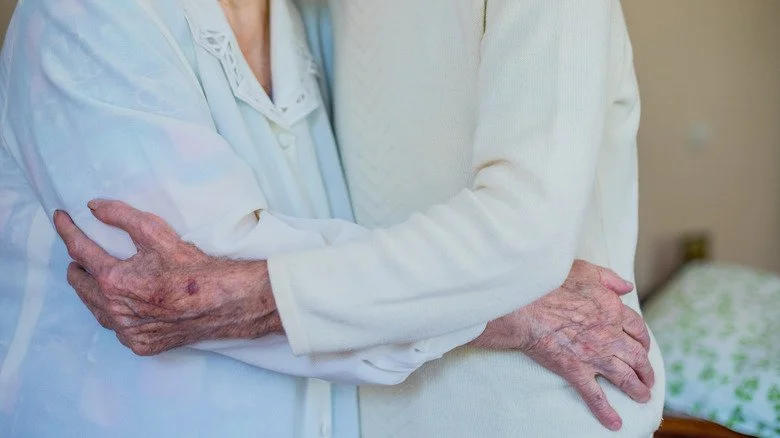 Couple âgé s'enlaçant