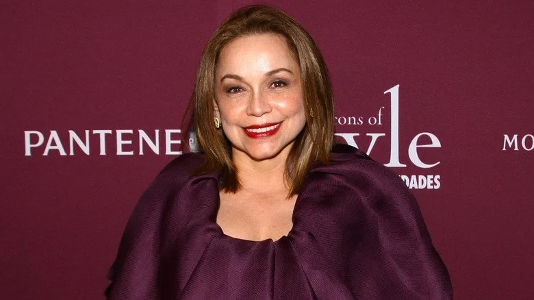 Nancy Gonzalez souriante sur fond bordeaux