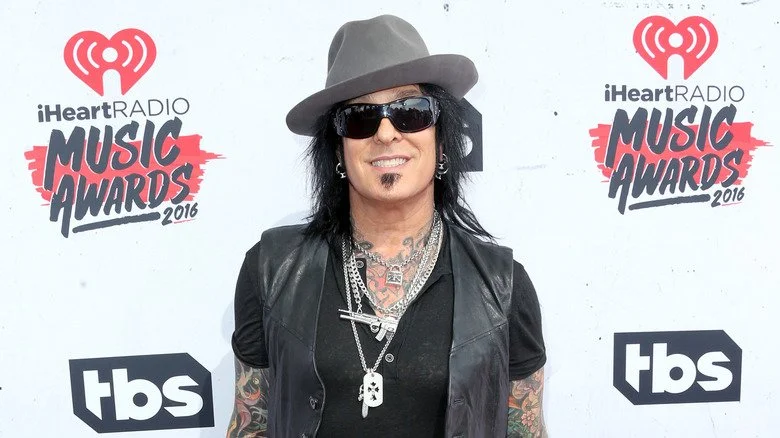 Nikki Sixx souriant avec des lunettes de soleil et un fedora