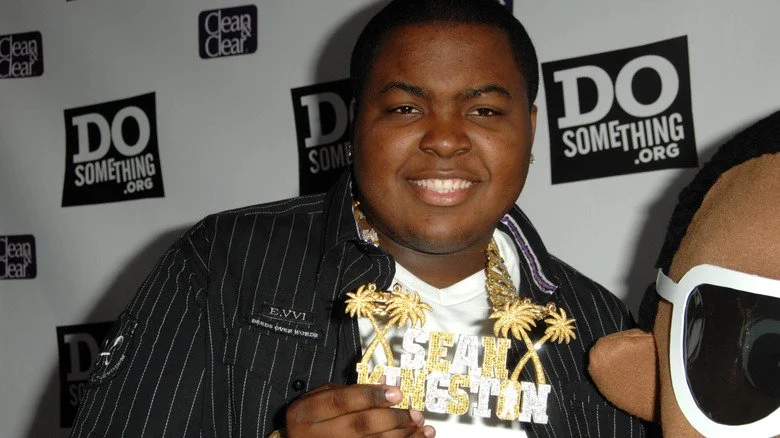 Sean Kingston souriant tenant un collier ID