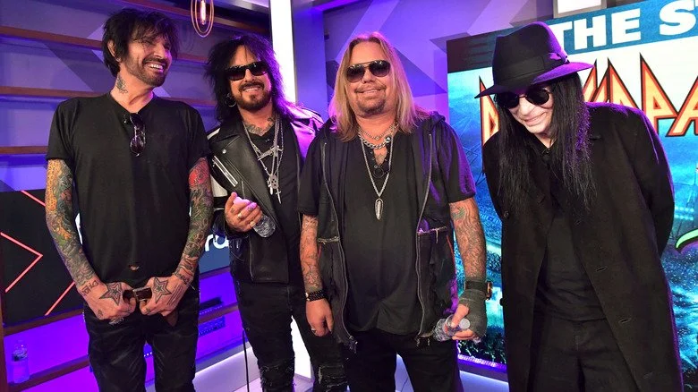Mötley Crüe, groupe en noir, souriant ensemble lors d'un événement