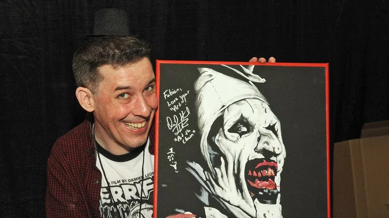 David Howard Thornton posant avec le poster d'Art le Clown