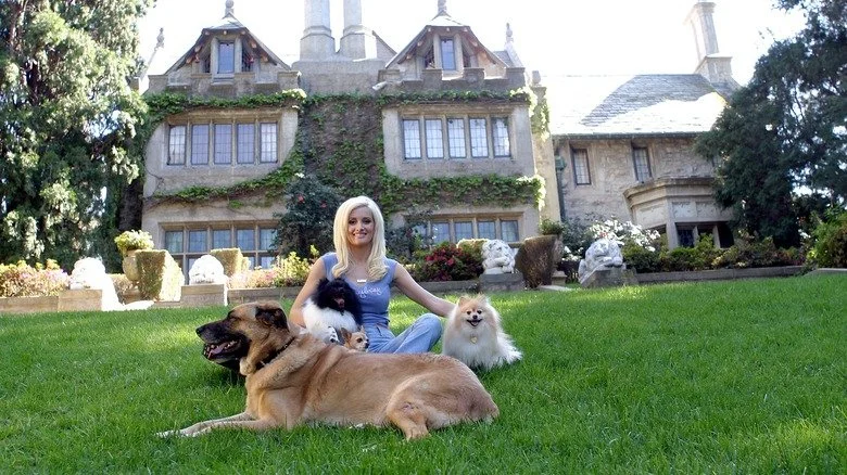 Holy Madison posant avec des chiens devant le Playboy Mansion