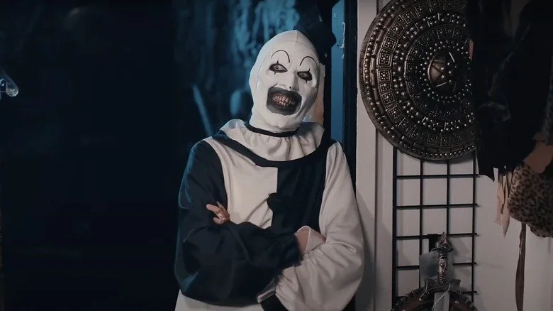 Art le Clown s'appuyant contre un mur