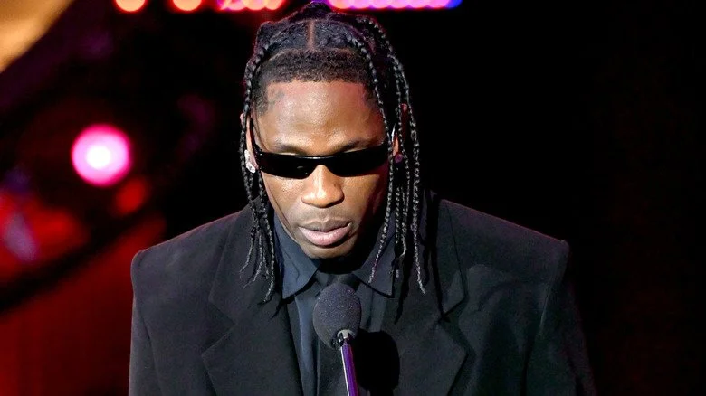 Travis Scott au micro en costume noir