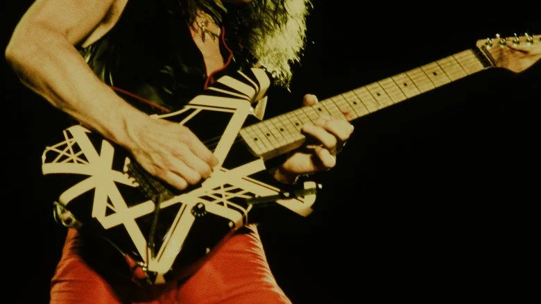 Eddie Van Halen jouant de la guitare rayée sur scène