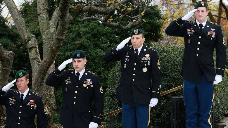 Quatre Green Berets saluant sur les marches
