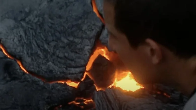 Bear Grylls regarde des roches de magma