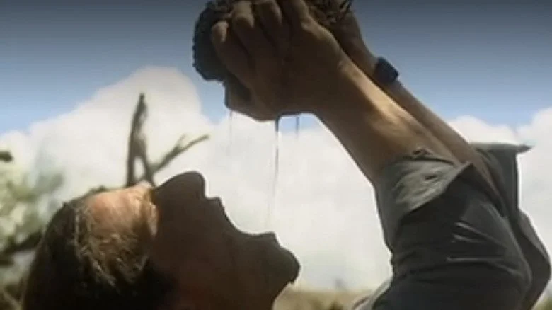 Bear Grylls buvant de l'eau provenant de crottes d'éléphant