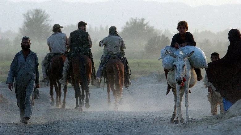 Green Berets sur des chevaux devant des habitants en Afghanistan