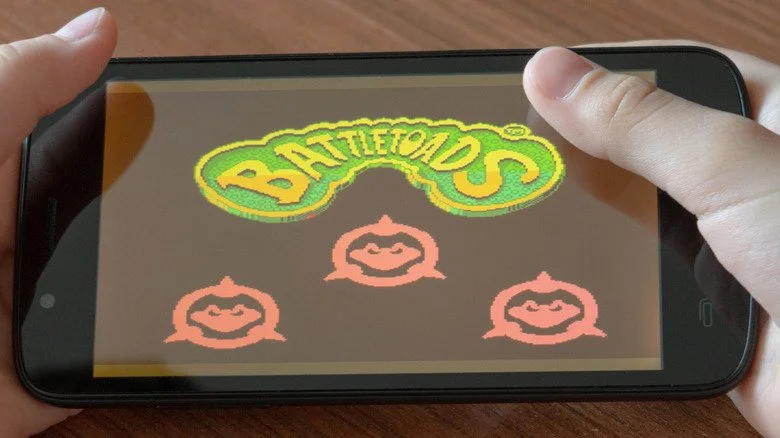 Enfant jouant à Battletoads sur le téléphone
