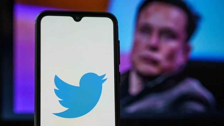 Elon Musk montrant Twitter sur son téléphone