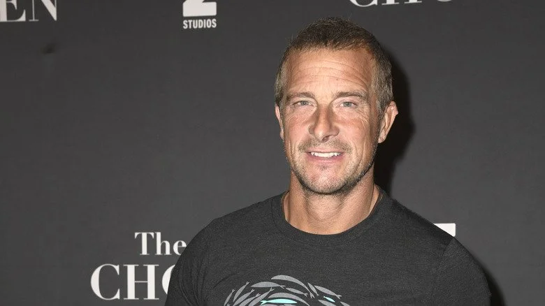 Bear Grylls posant pour une photo avec un T-shirt sombre