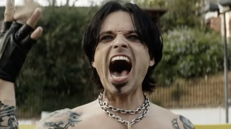 Sebastian Stan en tant que Tommy Lee avec un geste rock
