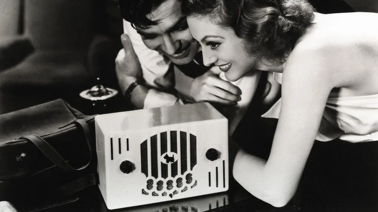 Clark Gable et Joan Crawford souriant devant une radio