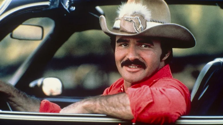 Burt Reynolds dans un chapeau de cowboy conduisant la voiture de Smokey and the Bandit